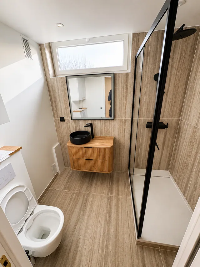 Salle de bain rénovée à Noisy-le-Roi avec meuble vasque bois et douche noire